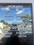 Horario hours decal on the front window of Mi Lindo Colima Mexican restaurant in Odell, Oregon listing weekday and weekend opening times in Spanish and English