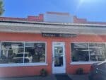 Coral pink building with a Mexican Restaurant sign, OPEN sign and micheladas window lettering at Mi Lindo Colima in Odell, Oregon