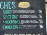 Pelinti Pizza sandwich menu board with chicken Caesar and meatball options in Hood River