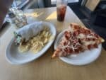 A Pelinti Pizza slice, fries, and iced drink on a table in Hood River